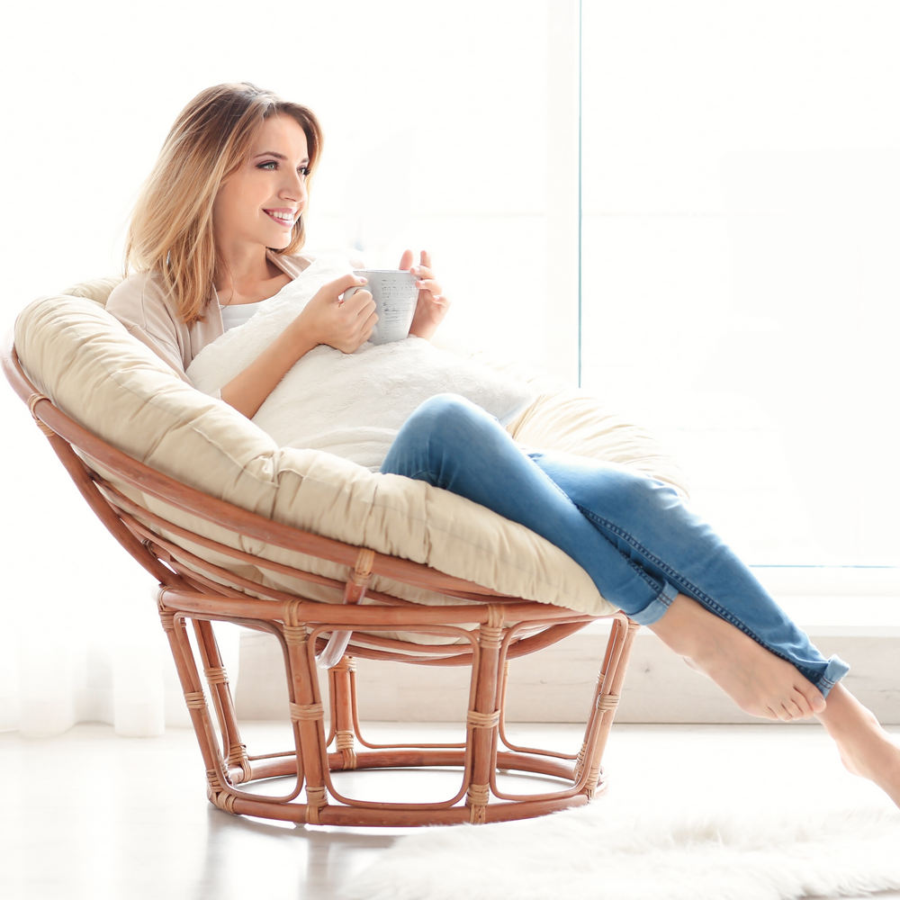 Happy,Young,Woman,Drinking,Tea,While,Sitting,In,Armchair,At