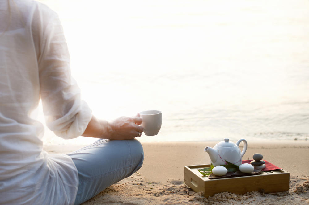 Woman,Meditating,And,Drinking, ChineseTea,On,Beach
